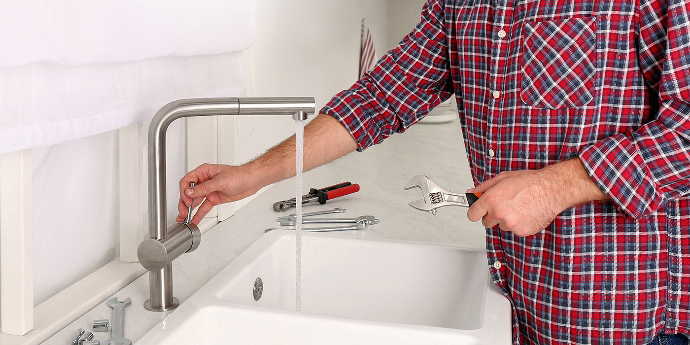 Plumber installing kitchen tap in London
