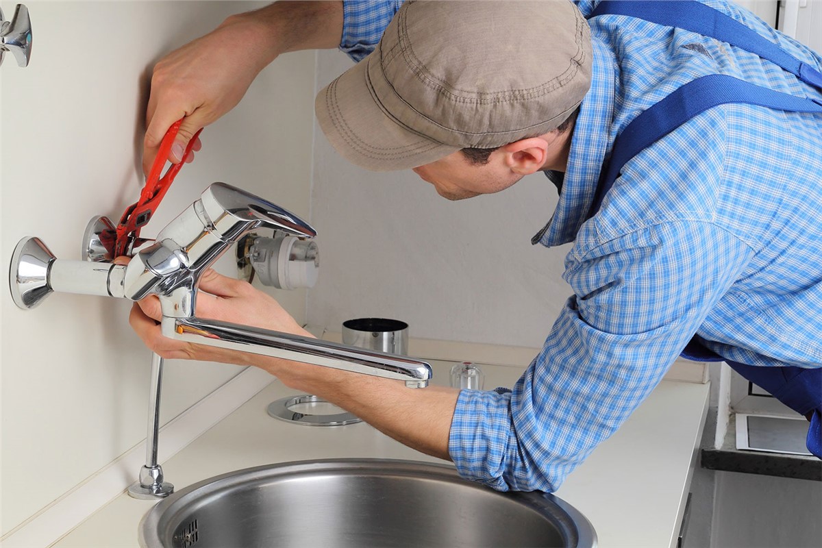 Plumber demonstrating kitchen tap installation